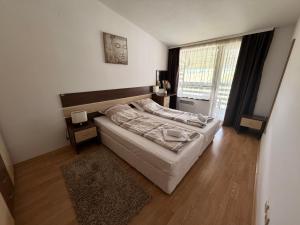 a bedroom with a bed and a large window at Aspen Luxury Apartament in Razlog