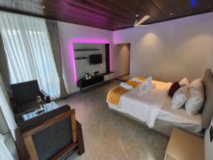 a hotel room with a bed and a tv at Coorg Tiger Eye Backwater Resort in Kushālnagar