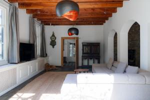 a living room with a white couch and a tv at Villa De Musschenberg in Beek
