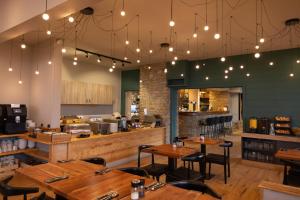a restaurant with wooden tables and chairs and lights at Alpeen Hotel in Les Menuires