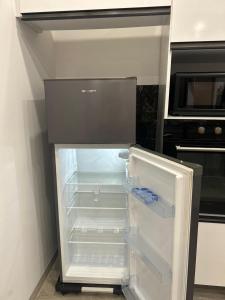 an empty refrigerator with its door open in a kitchen at Dar Selima Hammamet in Hammamet