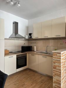 a kitchen with white cabinets and a sink at Apartman Helena in Senj