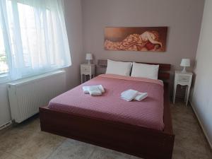 a bedroom with a bed with two towels on it at Summer apartment in Nea Peramos