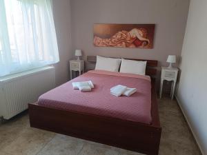 a bedroom with a bed with two towels on it at Summer apartment in Nea Peramos +5 photos