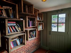 a brick wall with bookshelves filled with books at The Windmill Inn in Horsham