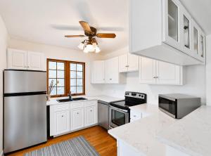 a kitchen with white cabinets and a ceiling fan at 58 River Rd. East in Wasaga Beach