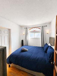 a bedroom with a blue bed with a window at 58 River Rd. East in Wasaga Beach