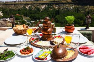 a table full of food with a view of a mountain at Cappadocia Nar Cave House & Swimming Pool in Nevşehir