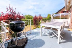 a grill and a table on a patio at L'Escale - Maison 5CH & Jardin in Bray-Dunes