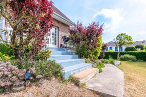 a house with stairs and flowers in front of it at L'Escale - Maison 5CH & Jardin in Bray-Dunes