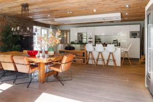 a kitchen and dining room with a wooden ceiling at Villa De Musschenberg in Beek