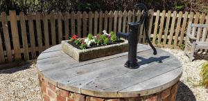 a circular wooden table with a flower garden on it at Pinecroft B&B in Lymington +1 photo