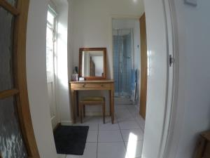 a bathroom with a vanity and a mirror on a table at Pinecroft B&B in Lymington