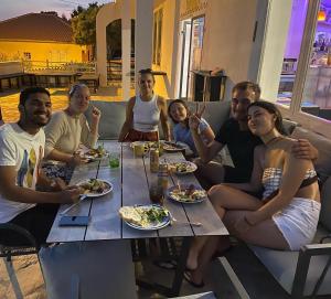 a group of people sitting around a table eating food at Hostel & Private Rooms Dalmatia in Marusici 