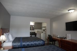 a hotel room with a bed and a desk with a computer at Aquarius Motel in Perth