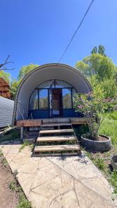 a small dome house with stairs in a yard at Swallow in Karakol