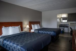 a hotel room with two beds and a kitchen at Aquarius Motel in Perth