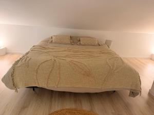 a bed in a bedroom with a wooden floor at L apparte Sciez in Sciez