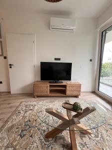 a living room with a flat screen tv and a coffee table at Olive II Apartman in Alsóörs