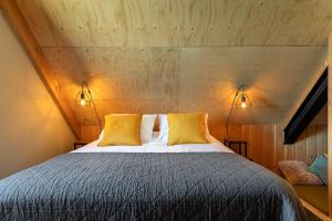 a bedroom with a bed with two yellow pillows at Lennepserf - T Farrel in Veessen