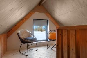 a room with two chairs and a window in a attic at Lennepserf - T Farrel in Veessen