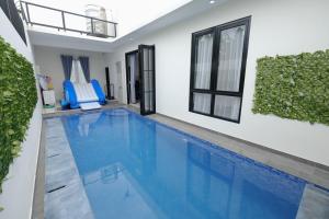 a swimming pool in a house with a chair in it at Abata Villa Panorama & Pool in Tingkirtengah
