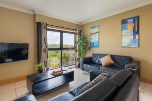 a living room with a couch and a tv at Canvas Cúirt na Coiribe Galway in Galway
