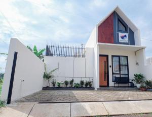 a small white house with a red door at Abata Villa Panorama & Pool in Tingkirtengah