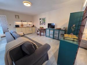 ein Wohnzimmer mit Sofa und Fernseher in der Unterkunft Poly's House in Tomares