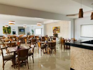 a dining room with tables and chairs in a restaurant at Hotel Tauari in Marabá