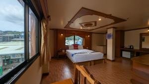 a bedroom with a bed and a large window at Tiger Complex Hotel and Restaurant in Patong Beach