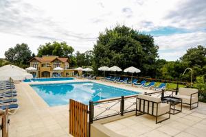 a large swimming pool with chairs and umbrellas at Mellmell en la Sierra in Tandil