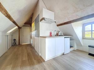 an attic kitchen with white cabinets and a window at Charming studio Terrace and parking in Le Mans