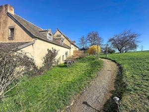 an old house with a dirt road next to a field at Charming studio Terrace and parking in Le Mans