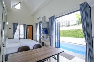a bedroom with a bed and a table with chairs at Abata Villa Panorama & Pool in Tingkirtengah