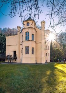 a large building with the sun behind it at Villa Rosenburg in Thale