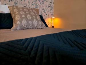 ein Bett mit einer blauen Bettdecke und einem Kissen in der Unterkunft Poly's House in Tomares + 4 Fotos