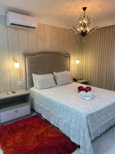 a bedroom with a bed with two shoes on it at Hotel Tauari in Marabá +121 photos