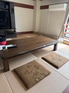 a living room with a wooden coffee table at Aizuwakamatsu Piacere in Aizuwakamatsu