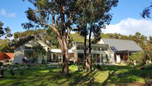 a house with a tree in the yard at Wilderness House in Margaret River Town