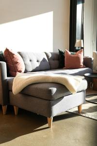 a couch with a blanket on it in a living room at Mosel Chalets - Design-Ferienhäuser - Terrasse und Traumblick, nähe Cochem - Direkt am Weinberg, Chalet Mitte mit Sauna in Pommern