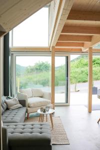 a living room with a couch and a table at Mosel Chalets - Design-Ferienhäuser - Terrasse und Traumblick, nähe Cochem - Direkt am Weinberg, Chalet Mitte mit Sauna in Pommern