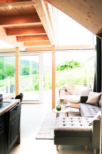 a living room with a couch and a table at Mosel Chalets - Design-Ferienhäuser - Terrasse und Traumblick, nähe Cochem - Direkt am Weinberg, Chalet Mitte mit Sauna in Pommern +99 photos
