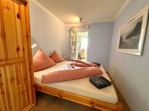 a bedroom with two beds with pink pillows on them at Ferienwohnung De Keef in Dorum-Neufeld
