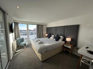 a hotel room with a large bed and a balcony at Tolbooth Apartments by Principal Apartments in Glasgow