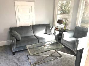 a living room with a couch and a glass coffee table at Downtown Lake Eola Historic House 1 OR 2 BED in Orlando