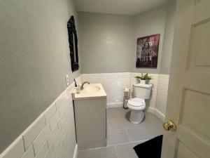a white bathroom with a toilet and a sink at Downtown Lake Eola Historic House 1 OR 2 BED in Orlando