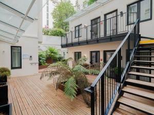 an outdoor deck with a staircase and plants at City Pop 2Night Paris - Self check-in in Vanves