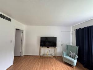 a living room with a television and a chair at Retro lake Eola 1 Bedroom Condo Thornton park in Orlando