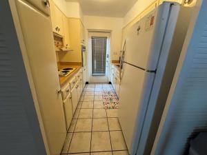 a kitchen with a refrigerator and a tile floor at Retro lake Eola 1 Bedroom Condo Thornton park in Orlando